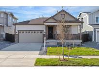 House exterior featuring a two-car garage and well-manicured lawn at 9723 Ceylon St, Commerce City, CO 80022