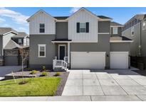 Two-story house with gray siding, white accents, and a two-car garage at 3077 Carabiner St, Castle Rock, CO 80108