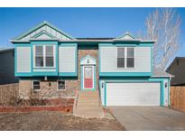 Cute two-story house with teal siding, red door, and attached garage at 11241 W 104Th Ave, Broomfield, CO 80021