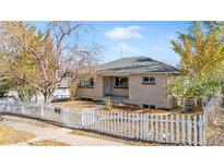 Brick ranch home with a landscaped yard and white picket fence at 3640 S Sherman St, Englewood, CO 80113