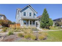 Two-story house with gray siding, front porch, and landscaped yard at 5977 Boston Ct, Denver, CO 80238