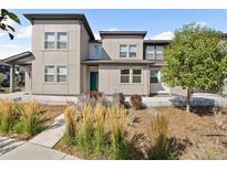 Modern two story townhome with teal door and landscaping at 16083 E 47Th Pl, Denver, CO 80239