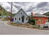 Gray house with a charming front porch, nestled in the mountains at 314 1St Ave, Idaho Springs, CO 80452