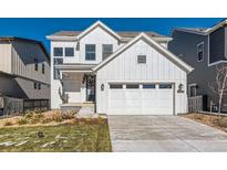 Two-story farmhouse style home with white exterior and attached garage at 9175 Cloud Shadow Ln, Littleton, CO 80125