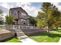 Two-story townhome with a landscaped yard and white picket fence at 3965 Nordland Trl, Castle Rock, CO 80109