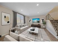 Bright living room with hardwood floors, neutral walls, and a staircase at 1827 Quail St # 3, Lakewood, CO 80215