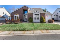 Brick two-story house with attached garage and landscaped lawn at 920 Home Farm Cir, Denver, CO 80234