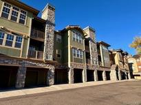 Attractive three-story building with stone accents and attached garages at 15460 Canyon Gulch Ln # 307, Englewood, CO 80112