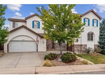 Two-story house with white exterior, blue shutters, and a two-car garage at 2891 Canyon Crest Dr, Highlands Ranch, CO 80126