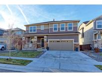 Two-story home with attached garage and landscaped front yard at 9299 Rifle St, Commerce City, CO 80022