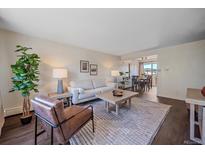 Bright living room features a comfy sofa, stylish coffee table, and large windows at 3744 Miller Ct, Wheat Ridge, CO 80033