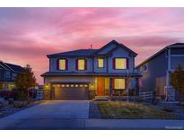 Two-story house with gray siding, red accents, and a two-car garage at 3438 Cade Ct, Castle Rock, CO 80104