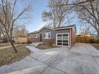 Brick ranch home with gray siding, attached garage, and landscaped yard at 6897 Newcombe St, Arvada, CO 80004