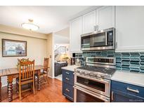 Updated kitchen with stainless steel appliances and blue cabinetry at 8314 S Everett Way # B, Littleton, CO 80128