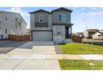 Two-story house with gray siding and two-car garage at 13502 E 100Th Ave, Commerce City, CO 80022