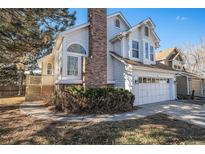 Two-story home with brick chimney and attached garage at 1147 S Flower Cir, Lakewood, CO 80232