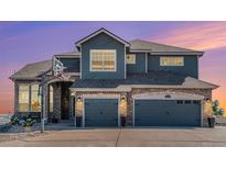 Two-story house with stone and gray siding, three-car garage, and basketball hoop at 9508 E 147Th Ave, Brighton, CO 80602