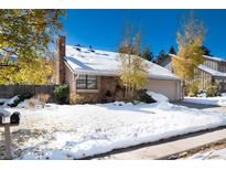 Brick home exterior with snow-covered landscaping and a two-car garage at 6350 E Mineral Pl, Centennial, CO 80112