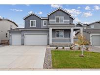 Two-story home with gray siding, three-car garage, and landscaped front yard at 5758 Ranch St, Mead, CO 80504