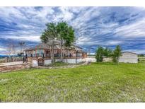 Two-story house with large deck, detached garage, and expansive yard at 1820 S State Highway 83, Franktown, CO 80116