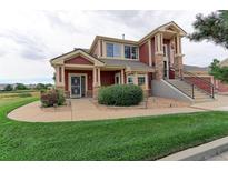 Two-story home with red exterior, landscaping, and walkway at 13722 Legend Way # 101, Broomfield, CO 80023