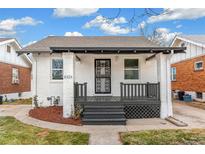 Charming brick home with a gray porch and landscaping at 4424 Decatur St, Denver, CO 80211
