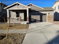 Ranch-style home with attached garage and landscaped front yard at 4799 Astor Pl, Brighton, CO 80601