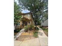 Two-story tan home with a front porch, steps, and landscaping at 1514 S Buckley Way, Aurora, CO 80017