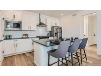 Modern kitchen with white cabinets, island, and breakfast bar at 356 N Geneva St, Aurora, CO 80010