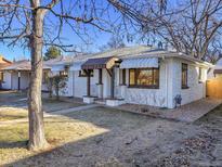 Charming ranch home with white brick exterior and landscaped yard at 1130 Locust St, Denver, CO 80220