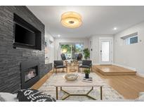 Living room with a modern fireplace and hardwood floors, view of kitchen at 2025 W 35Th Ave, Denver, CO 80211