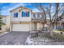 Charming two-story home with a front porch, attached garage, and landscaping at 1214 S Akron Way, Denver, CO 80247