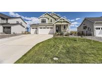 Two-story craftsman style home with a three-car garage and landscaped lawn at 39286 Hart Cir, Elizabeth, CO 80107