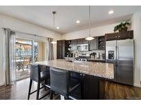 Modern kitchen with granite countertops, stainless steel appliances, and an island at 10800 Richfield Cir, Commerce City, CO 80022