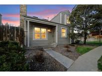 Charming two-story home with a welcoming front porch and landscaped yard at dusk at 11895 E Cornell Circle, Aurora, CO 80014