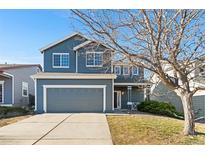 Two-story house with gray siding, attached garage, and landscaping at 3675 S Himalaya Ct, Aurora, CO 80013