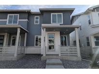 Two-story home with gray siding and a white front porch at 8487 Eagle River St, Littleton, CO 80125