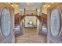 Elegant entryway with a grand double staircase and hardwood floors at 10690 County Road 1, Longmont, CO 80504