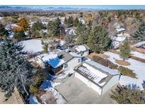 Aerial view of a ranch style home with a detached garage, large yard, and mountain views at 6101 S University Blvd, Centennial, CO 80121