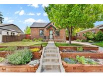 Brick home with landscaped yard and walkway at 1454 Rosemary St, Denver, CO 80220