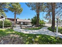Inviting pool area with a walking path, landscaping, and a tranquil water feature at 9995 E Harvard Ave # 179, Denver, CO 80231