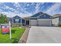 Two-story home with three car garage and manicured lawn at 18352 W 95Th Pl, Arvada, CO 80007