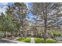 Front view of a townhome with landscaping and mature trees at 1470 S Quebec Way # 27, Denver, CO 80231