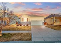 House exterior at dusk showcasing landscaping and driveway at 114 Apache Plume St, Brighton, CO 80601