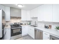 Updated kitchen with white cabinets and stainless steel appliances at 9155 E Center Ave # 4B, Denver, CO 80247