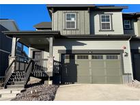 Two-story home with gray siding, attached garage, and a covered front porch at 1317 Sunrise Dr, Erie, CO 80516