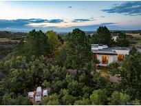 Aerial view of a modern home with a detached garage, showcasing expansive views and landscaping at 3823 Castle Butte, Castle Rock, CO 80109