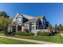 Two-story home with gray siding, red door and landscaped yard at 13900 Lake Song Ln # B6, Broomfield, CO 80023