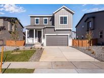 Two-story house with gray siding, a gray door, and a two-car garage at 13521 E 99Th Pl, Commerce City, CO 80022