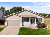 Ranch-style home with attached garage and manicured lawn at 1021 Berganot Trl, Castle Pines, CO 80108